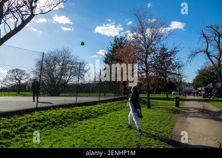 Una coppia che si diverse a giocare una partita di palla in un parco locale nel nord di Londra. Cielo soleggiato blu nel Sunny Hill Park, Hendon. Foto Stock