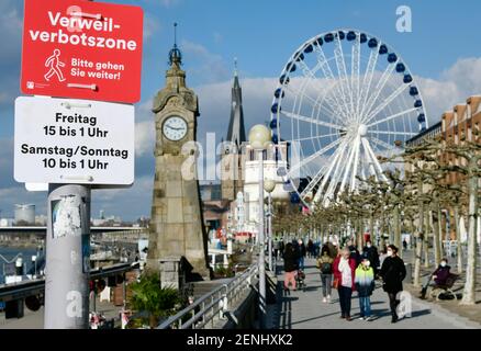 Duesseldorf, NRW Germania, 26 febbraio 2021, Corona, "Please walk on": A causa della folla di persone lo scorso fine settimana, la città di Düsseldorf ha imposto un divieto sulla passeggiata sul Reno nella città vecchia. Questo si applica il venerdì dalle 15:00 all'1:00 e il sabato e la domenica dalle 10:00 all'1:00 del mattino, è ancora alle 14:50 del venerdì e la gente usa il tempo sulle panchine del parco. Foto Stock