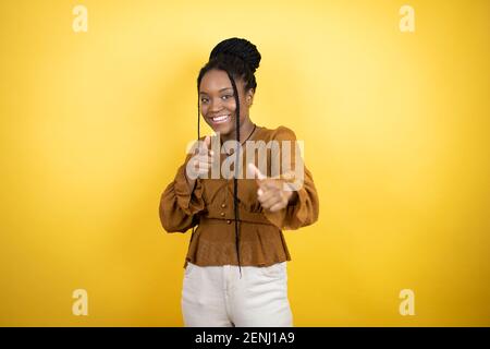 Donna afroamericana che indossa abiti casual che indicano a te e la fotocamera con le dita, sorridente positivo e allegro Foto Stock