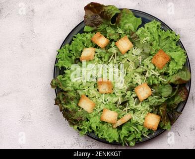 Caesar insalata in un piatto su uno sfondo chiaro. Vista dall'alto, disposizione piatta Foto Stock