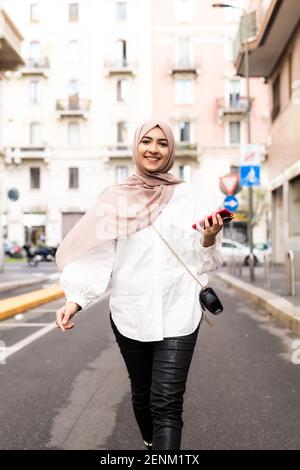 Giovane musulmana che cammina in città Foto Stock