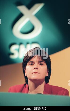 Nicola Sturgeon del Partito Nazionale Scozzese ha ascoltato il leader del suo partito Alex Salmond rivolgendosi ai media al lancio del manifesto 1999 dell'SNP per la campagna elettorale di Holyrood a Edimburgo, Scozia. La sig.ra Sturgeon è stata eletta nel nuovo parlamento scozzese nel 1999 e ha continuato a servire come vice primo ministro del paese sotto la guida di Alex Salmond MSP e poi come primo ministro. All'epoca delle elezioni del 1999 lavorava come avvocato nel DrumChapel Law and Money Advice Center di Glasgow. Foto Stock