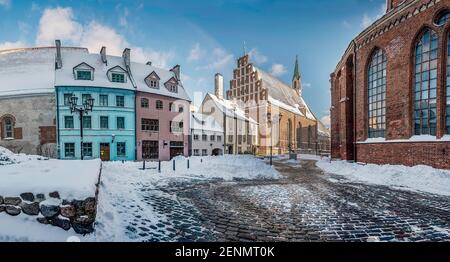 Coperto di strada innevata nel centro storico della città di riga. Case storiche vicino alla chiesa di San Pietro in inverno a riga, Lettonia Foto Stock