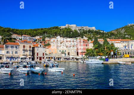 Hvar, Croazia - 2 ottobre 2011: Vista delle barche e delle vecchie case tradizionali con la Fortezza spagnola sullo sfondo Foto Stock