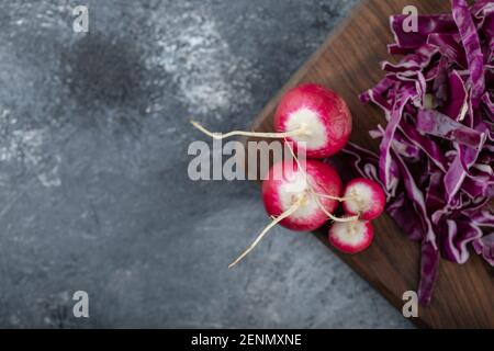 Cavolo tritato e rafano su tavola di legno su sfondo grigio Foto Stock