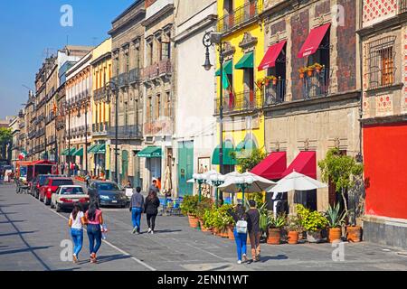 I turisti camminano lungo edifici coloniali spagnoli, ristoranti e negozi sulla Calle Tacuba nel quartiere storico di Città del Messico, Messico Foto Stock