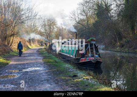 Camminando sulle barche del canale ormeggiate accanto all'alzaia del canale Kennett e Avon in una giornata invernale luminosa. Bradford on Avon, Wiltshire, Inghilterra, Regno Unito Foto Stock