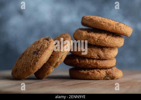 Pila di deliziosi biscotti al cioccolato su tavola di legno Foto Stock