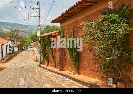 Piccolo vicolo storico con ciottoli di pietra arenaria nella storica città coloniale di Barichara in Colombia, una popolare destinazione turistica in Foto Stock