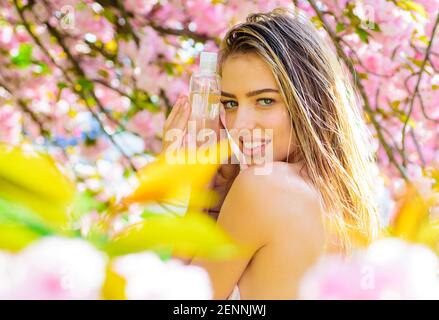 Tonico facciale. Ragazza sorridente con acqua micellare. Rimuovi trucco. Cosmetici e trattamenti di bellezza. Foto Stock