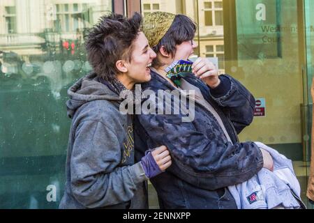 Londra, Regno Unito. 26 febbraio 2021. Blue (18) e Nemo (20) ridono come swampy (Daniel Hooper, 48) spruzzi champagne su di loro mentre lasciano Westminster Magistrates Court. L'albero di loro lasciò le gallerie sotto Piazza Euston giovedì 25 febbraio 2021. Un piccolo bagno di gloria e di affetto organizzato da colleghi attivisti e amici li attende. Foto Stock
