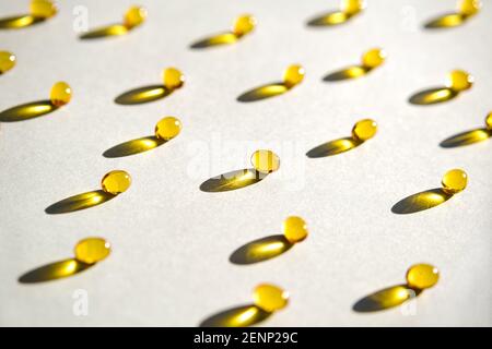 Capsule di gel trasparente gialle di vitamina d o omega 3 in cucchiaio. Foto Stock