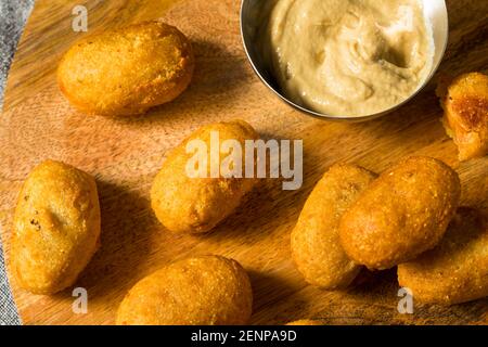 Mini cani di mais fritti fatti in casa con senape gialla Foto Stock