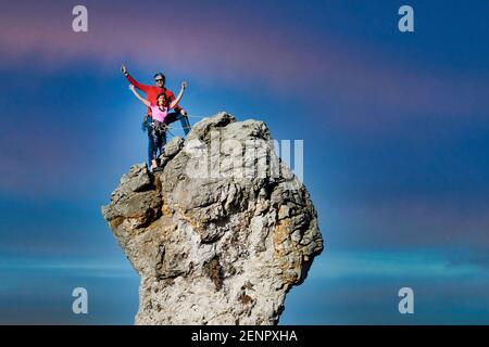 Due arrampicatori maschili e femminili sulla cima di una roccia picco Foto Stock