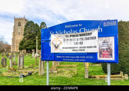 Tutti i luoghi di culto pubblici sospesi fino a ulteriore avviso cartello fuori della chiesa del villaggio di Norfolk. Foto Stock