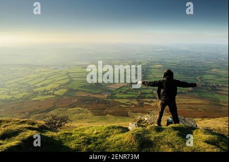 Un uomo che ama godersi l'emozionante vista dalla cima di Mynydd Troed nelle Black Mountains, Galles, Regno Unito. Foto Stock