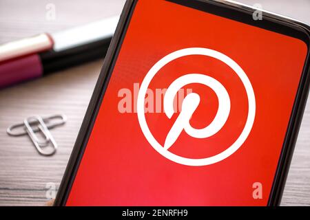 icona rossa pinterest sullo schermo del telefono. app per smartphone social network per foto con logo sul display. Italia, Milano, 26-02-21 Foto Stock