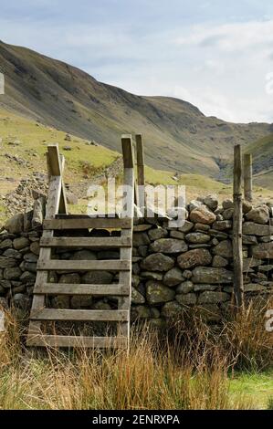 Una stiglia di legno su un muro di pietra arenaria su un sentiero vicino Hartsop nel Lake District, UK. Foto Stock