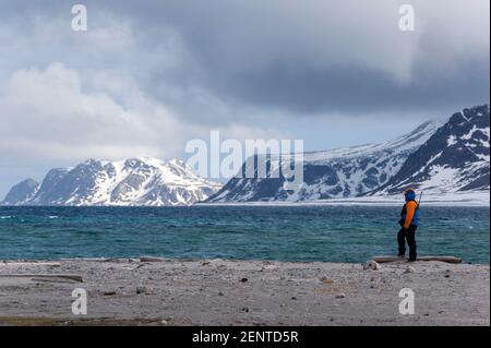 Una guida naturalistica che controlla i dintorni, il fiordo di Smeerenburg, Amsterdam damoya, Spitsbergen, le isole Svalbard, Norvegia. Foto Stock