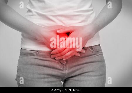 La donna della persona sente il dolore nell'intestino dell'addome inferiore. Foto Stock