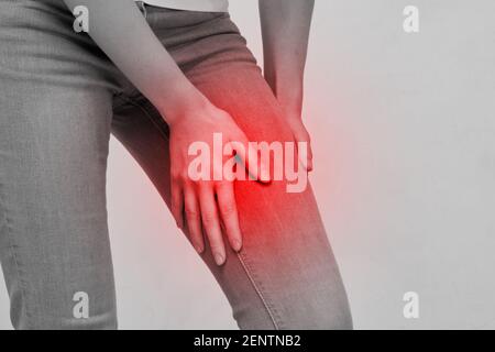 La donna della persona sente il dolore nella parte della coscia della gamba. Foto Stock