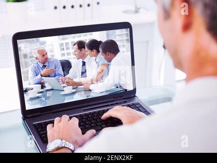 Vista laterale delle persone durante una chiamata visio sul computer Foto Stock