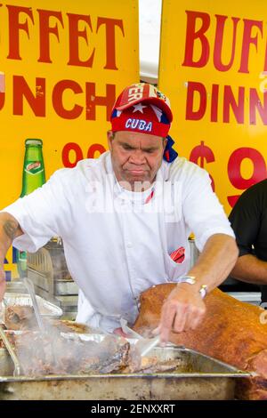 Salsa sulle scene del festival di St. Clair: Un cuoco ad un supporto del cibo si acciglia in concentrazione mentre gira sopra carne succulente-osservante in un servizio fumante Foto Stock