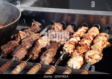 Shashlik preparandosi su una griglia di barbecue sopra carbone. Carne calda arrosto per cena barbecue Foto Stock