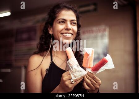 Attraente giovane donna messicana alternativa sorridente con gelati Foto Stock