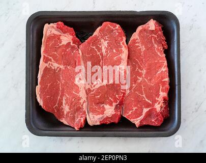 Bistecca di manzo marmorizzato su un negozio di alimentari con vassoio di polistirolo Foto Stock