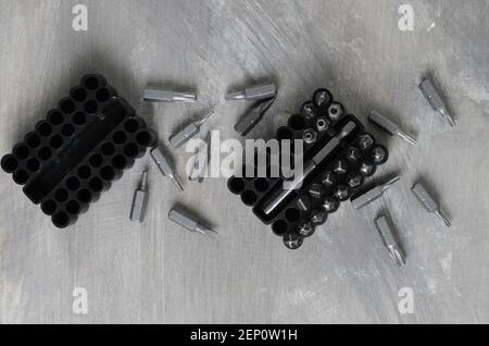 Punte per cacciaviti per vari standard in un pratico contenitore su fondo in cemento grigio. Messa a fuoco selettiva. Foto Stock