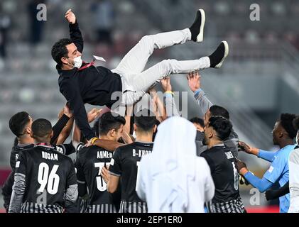 Doha, Qatar. 26 Feb 2021. I giocatori di al Sadd SC lanciano in aria il capo allenatore Xavier Hernandez (top) dopo aver vinto la partita finale della Qatar Cup tra al Sadd SC e al Duhail SC a Doha, Qatar, 26 febbraio 2021. Credit: Nikku/Xinhua/Alamy Live News Foto Stock