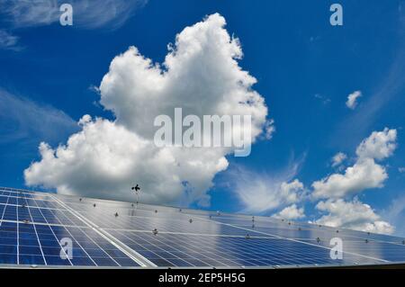 Vista spettacolare dei pannelli solari fotovoltaici fotoelettrici e delle grandi nuvole e del cielo blu, Craftsbury Outdoor Center, VT, USA. Foto Stock