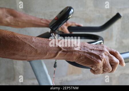 "i nostri allenatori utilizzano la tecnologia attuale", mamma di 80 anni che usa una moderna bicicletta da ginnastica per il suo allenamento quotidiano. Foto Stock