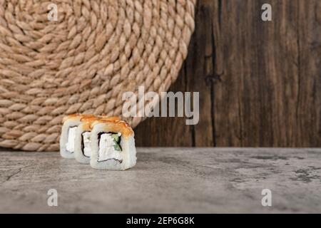 Set di panini caldi di sushi impanati su un tavolo di pietra Foto Stock