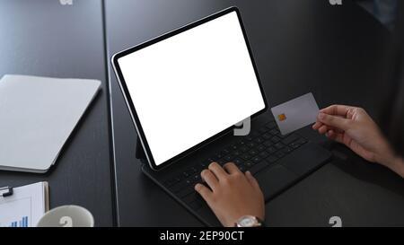 Primo piano vista delle mani di businesswoman che tengono la carta di credito e che utilizzano computer tablet shopping online o internet banking. Foto Stock