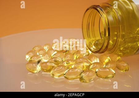 Alcune capsule molli di omega 3, olio di merluzzo, vitamina D e vitamina A. Foto Stock