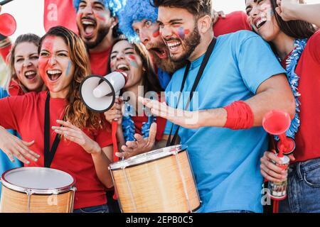 Gli appassionati di sport pazzi gridano mentre sostengono la loro squadra fuori Lo stadio - Focus sulla faccia destra dell'uomo Foto Stock