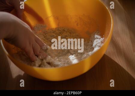 Donna che mescola farina e acqua per preparare un impasto Foto Stock