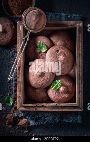 Frittelle di cioccolato fatte in casa in una vecchia scatola di legno / piastra di ceramica su tavolo scuro Foto Stock