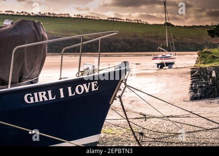 La prow della barca a motore Girl i Love ormeggiata sulla riva del fiume Gannel a bassa marea a Newquay in Cornovaglia. Foto Stock