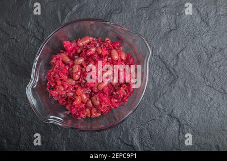 Ciotola di vetro di cavolo sottaceto con fagioli rossi su nero sfondo Foto Stock