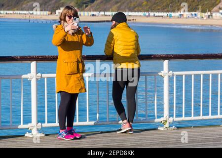 Bournemouth, Dorset UK. 27 febbraio 2021. Tempo nel Regno Unito: Bella giornata calda e soleggiata con cielo blu e sole ininterrotto alle spiagge di Bournemouth mentre le persone si dirigono verso il mare per il loro esercizio quotidiano durante Lockdown 3. Credit: Carolyn Jenkins/Alamy Live News Foto Stock