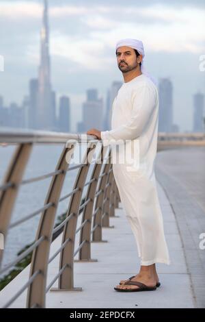 uomo degli emirati al lungomare di al Jaddaf a Dubai con Burj Khalifa sullo sfondo Foto Stock