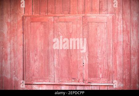 Finestra decorativa rossa su un vecchio muro di legno rosso Foto Stock