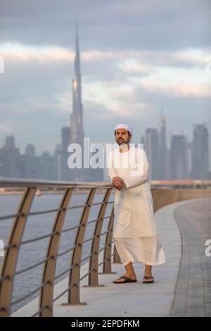 uomo degli emirati al lungomare di al Jaddaf a Dubai con Burj Khalifa sullo sfondo Foto Stock