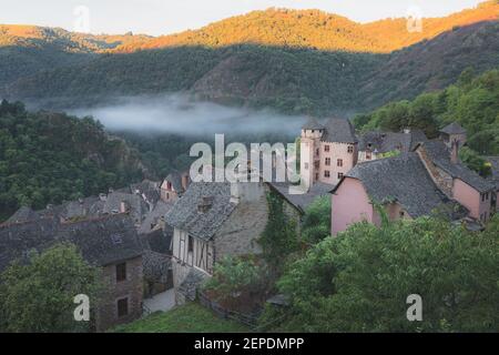 Vista sulla collina del pittoresco e affascinante borgo medievale francese di Conques, Aveyron, una popolare destinazione turistica estiva nella regione delle Occitanie Foto Stock