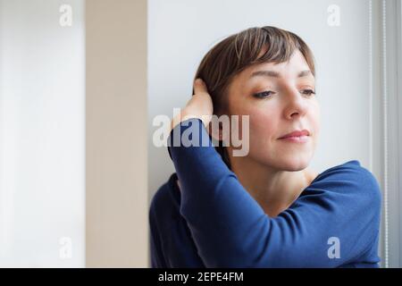 Ritratto in primo piano di una donna dai capelli corti in luce naturale Foto Stock