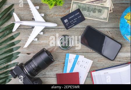 Documenti, biglietti aerei e altre forniture di viaggio su sfondo ligneo. Vista dall'alto. Foto Stock