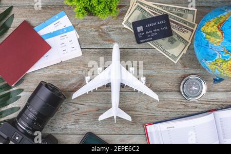 Documenti, biglietti aerei e altre forniture di viaggio su sfondo ligneo. Vista dall'alto. Foto Stock